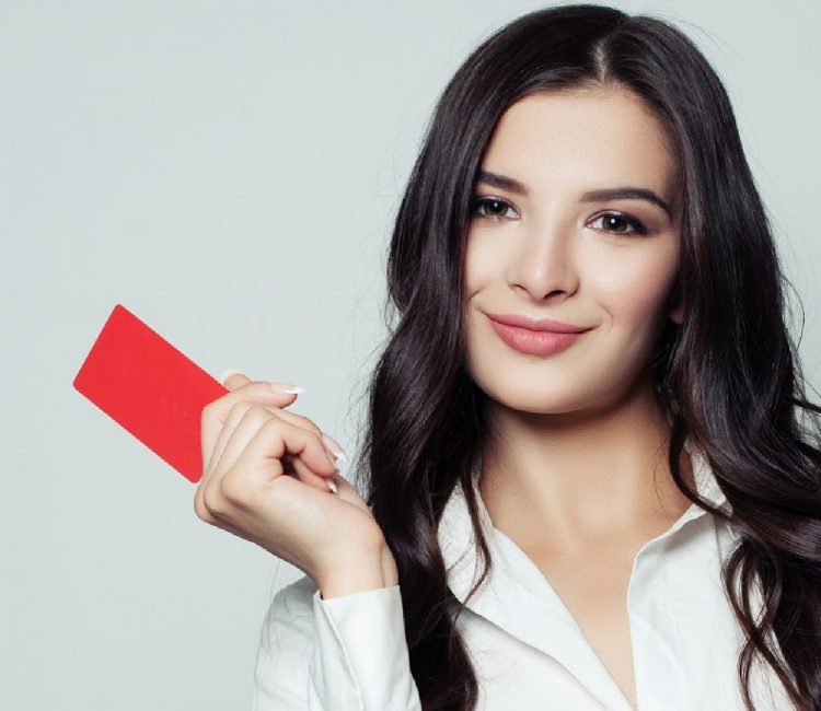 Smiling business woman with red blank card. Young woman holding empty card in her hands. Business, advertising marketing and product placement concept
